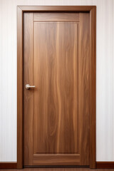 A modern walnut wooden door with a platband against white wall