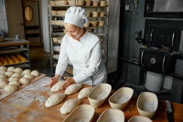 Foto op Plexiglas Professional positive woman baker forming loaf from raw dough © Nomad_Soul