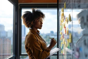 Foto op Canvas Young African american executive manager businesswoman writing strategy ideas on sticky notes on whiteboard doing business project presentation in contemporary corporate office, Generative AI  © Ashutosh