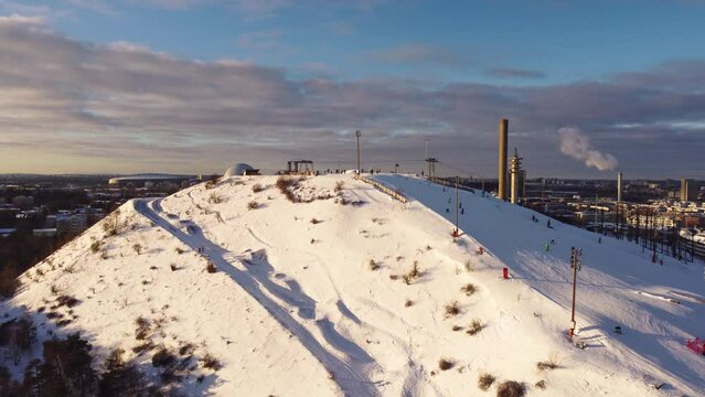 Aerial view of the Stockholm ski slopes at Hammarbybacken, near the district of Hammarby. The Ericsson Globe in the background. Partly cloudy, bright light. Snow, winter. Sweden