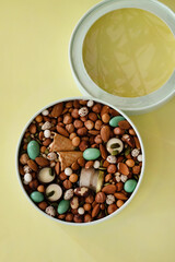 On a light background there is a round box filled with various nuts and dried fruits. Mothers Day. Valentine's Day. International Women's Day.A delightful gift. Low-fat food.