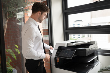 Caucasian businessman working with photocopier at office