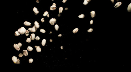 Falling pistachio nuts isolated on black