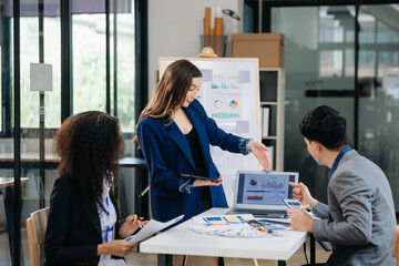 Group of young Asian business people discussing business plan at modern startup in creative business discussing work