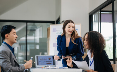 Group of young Asian business people discussing business plan at modern startup in creative business discussing work