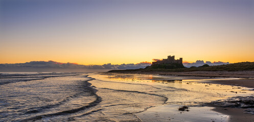 Beautiful landscape image of Northumberland beach in Northern England during Winter dawn with deep...