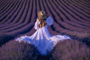 Back view woman lavender sunset. Happy woman in white dress holds lavender bouquet. Aromatherapy...