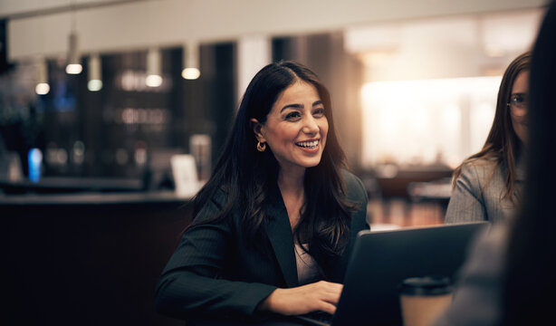 Businesswoman laughing during a meeting with colleagues in a hotel lobby