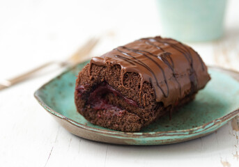 Delicious chocolate roll cake with  icing  and cherry filling. Drunk cherry cake