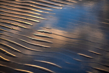Sand ripple patterns at the beach during the sunrise - 704312467