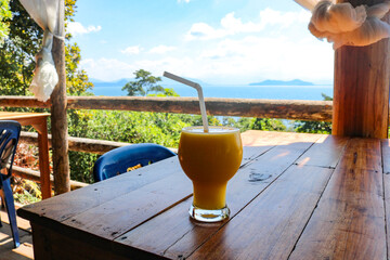 Fruit smoothie in a cafe overlooking the sea. The concept of relaxation, vacation, healthy...
