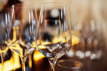 Extrime closeup of empty champagne glasses in a row. Wine goblet at wedding reception, alcohol bar, catering in restaurant.