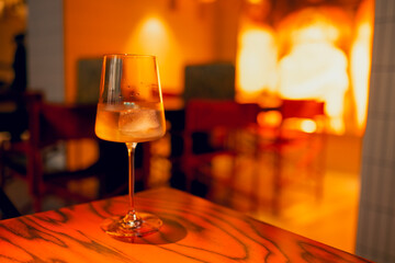 One delicious ice cold cocktail in exquisite glasses stand on a wooden table in a restaurant.