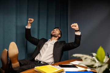 A cheerful businessman is relaxing and singing at his office. - obrazy, fototapety, plakaty