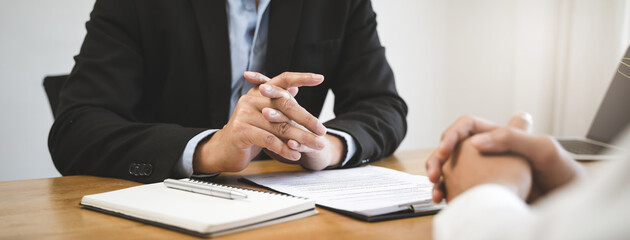 Employer or recruiter holding reading a resume during his profile of candidate, employer in suit is...