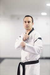 A taekwondo trainer in attack position at martial art school.