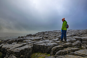 Hiker on top of Malham Cove mountain