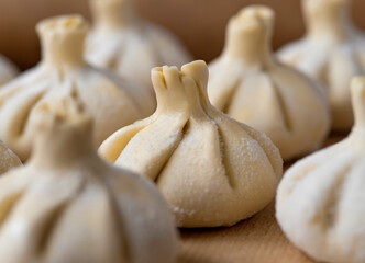 Raw frozen khinkali  on wooden table. Process preparation georgian meal. food concept.
