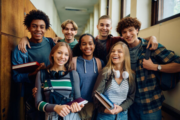 Multiracial group of happy classmates at high school looking at camera.
