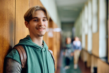 Fototapeta premium Smiling teenager at high school hallway looking at camera.