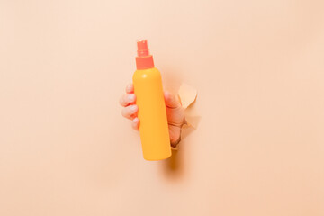 Hand holding cosmetic spray container (for skin or hair). Cosmetic beauty packaging