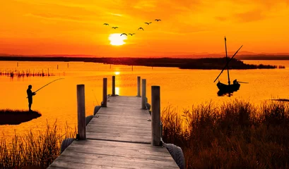 Poster Im Rahmen anaranjado amanecer en el lago con un embarcadero © kesipun
