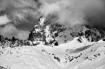 Black and white view on mount Ushba in fog at sun winter day before storm - 704332656