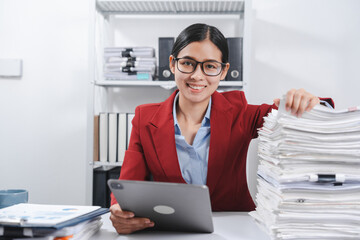 cheerful individual wearing glasses and a red blazer, hard working with large stack of papers,...