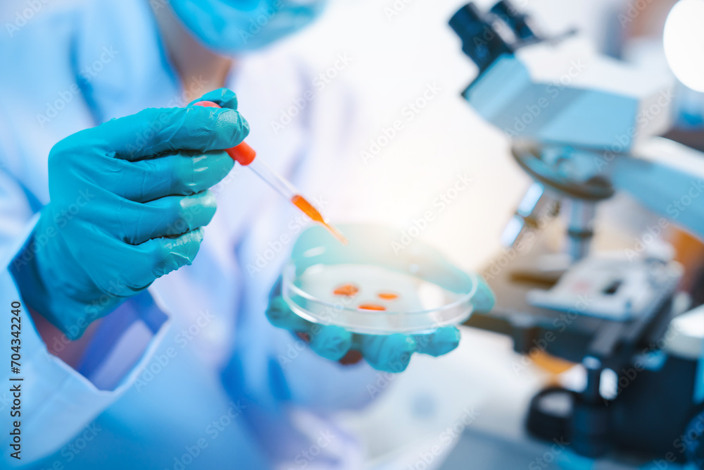 Wall mural asian people scientist in lab coat and protective gloves working with test tubes with green and red 