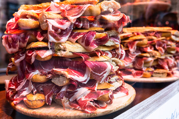 Mouth watering sandwiches with jamon laid out in a slide on shop window