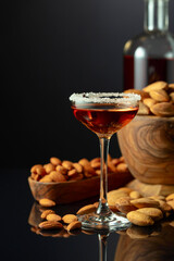 Italian liqueur Amaretto with almonds nuts on a black background.