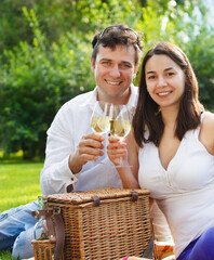 Young happy couple enjoying a glasses of white wine