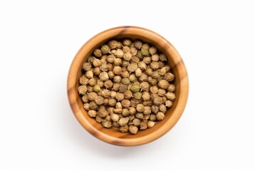 Fototapeta premium flat lay top view of dried coriander seeds in the wooden bowl isolated on white background. generatif ai