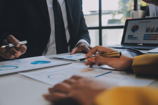 Financial analysts analyze business financial reports on a digital tablet planning investment project during a discussion at a meeting of corporate showing the results of their successful teamwork.