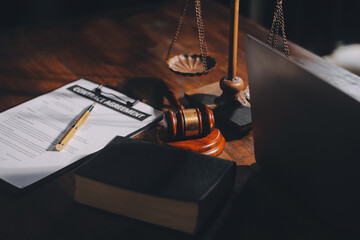 image of judge's hammer, scales lady of justice, law book, laptop computer and contract documents with pen concept of law and justice.
