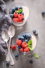Homemade and tasty Panna Cotta with blueberries and raspberries.