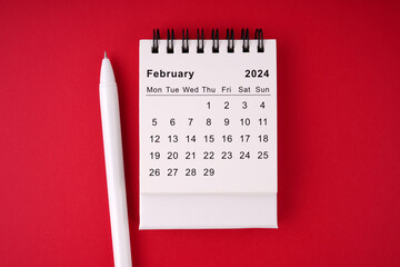 Calendar and pen on a red background. 