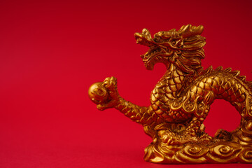 Chinese golden dragon statue on a red background.