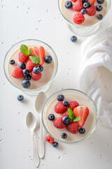 Sweet and vanilla Panna Cotta served in glass with berries.