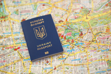 biometric passport of Ukraine of blue color with a trident on the Berlin city map background