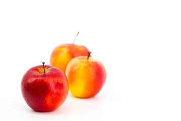 A captivating image featuring vibrant red apples set against a pristine white backdrop. The stark contrast accentuates the apples' freshness, creating a visually appealing and elegant composition.
