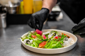 chef hands cooking salad with vegetables on kitchen