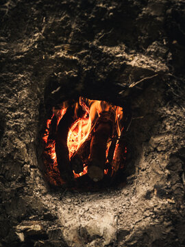 Traditional ground oven with a campfire inside