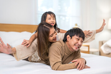Fototapeta premium Portrait of enjoy happy love asian family father and mother holding hug cute little asian girl child smiling play and having fun moments good time, care, kid, support, insurance, child, at home