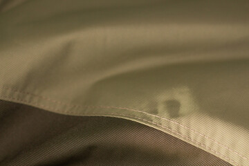 protective work clothes in beige and brown colors. Factory stitches on thick fabric. Close-up texture