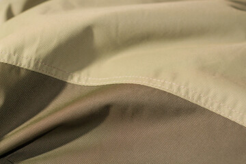 protective work clothes in beige and brown colors. Factory stitches on thick fabric. Close-up texture