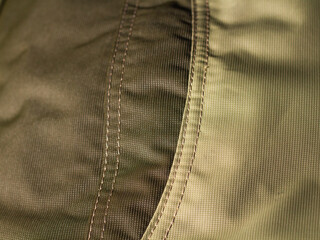 protective work clothes in beige and brown colors. Factory stitches on thick fabric. Close-up texture