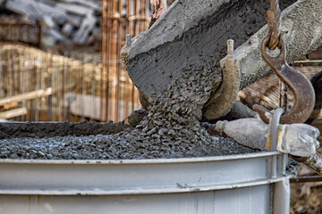 concrete from a concrete mixer is poured onto a construction site