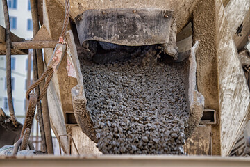 concrete from a concrete mixer is poured onto a construction site