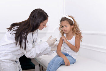 Vaccine fear in children, Little girl in face mask in doctor's office is vaccinated. Crying,...